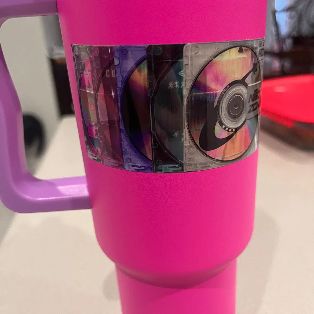 Holographic Mini Disc sticker on a hot pink water bottle 