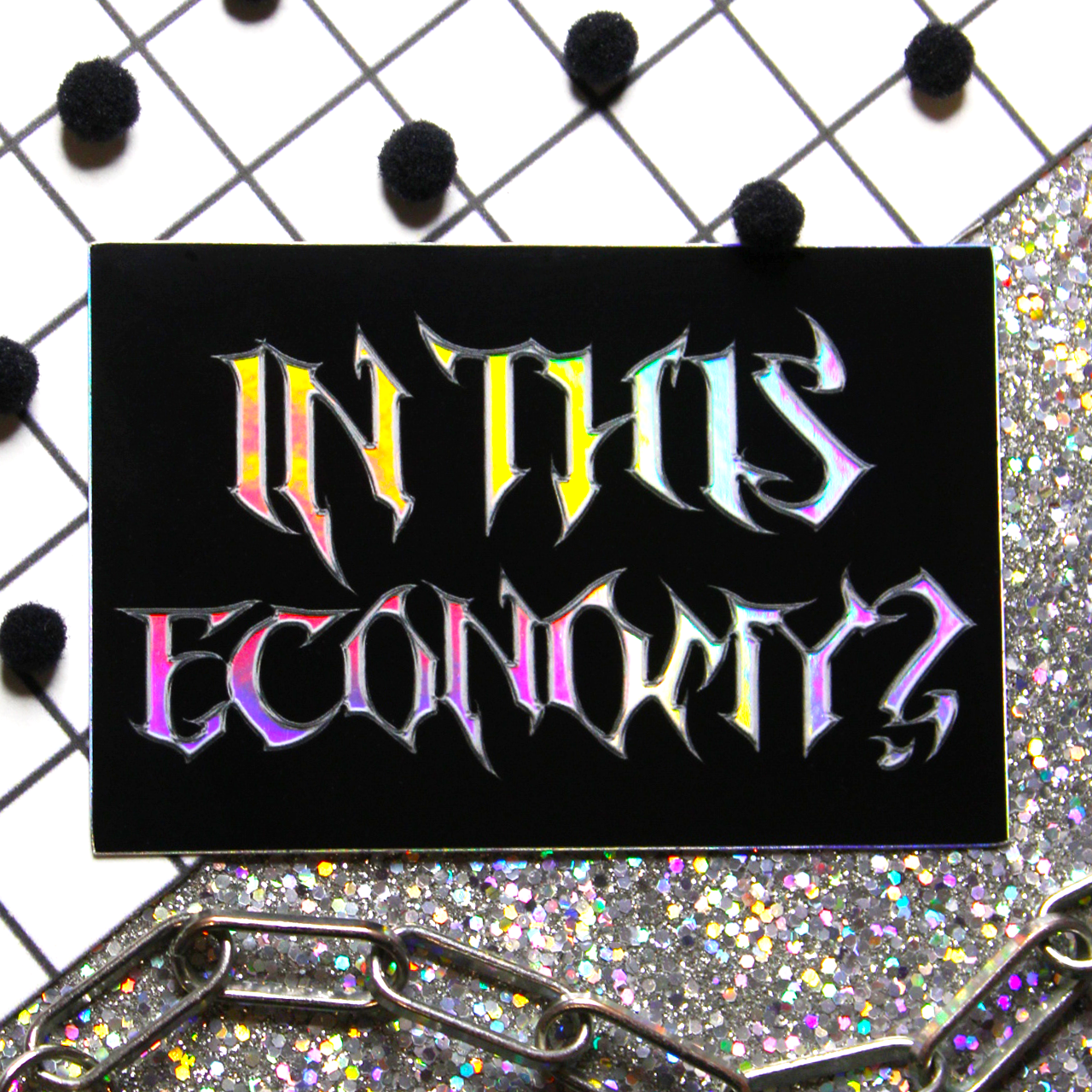 Holographic Metal font sticker with black background that says In this economy